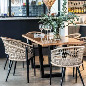 sillas de cuerda trenzada color beige con estructura de hierro negra con una mesa de tapa de madera y patas de hierro negro en un restaurant