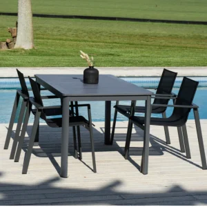 Conjunto de muebles de exterior GONESSE compuestouna mesa de aluminio extensible y 8 sillas de aluminio y textileno junto a una piscina